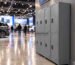 Hilera de lockers metálicos instalados en un pabellón de exposiciones durante una feria del automóvil